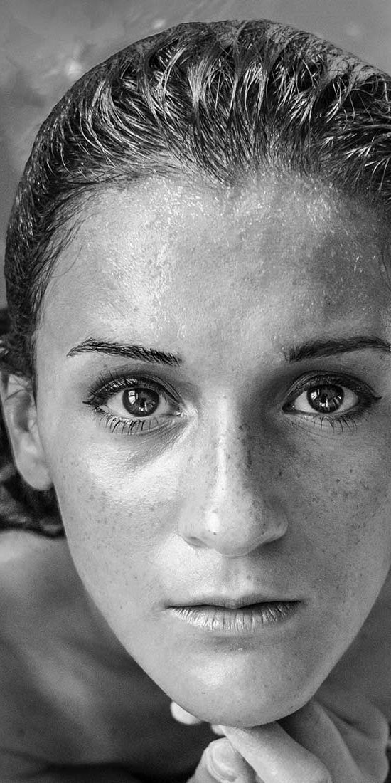 A woman with wet hair and no make up
