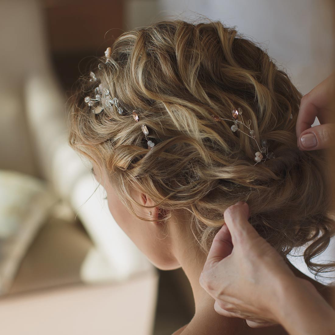 A woman is putting her hair in the back of her head.