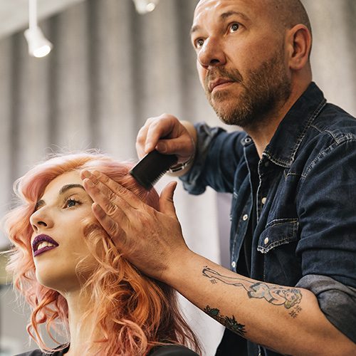 A man is cutting the hair of a woman.
