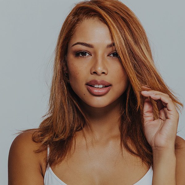 A woman with red hair is posing for the camera.