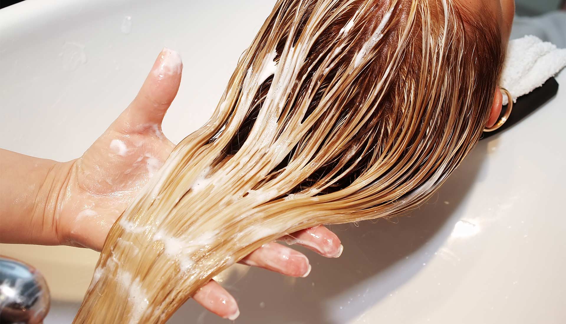 A person is washing their hair with soap.