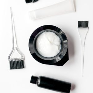 A white table with some hair products and brushes