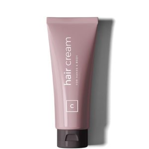 A tube of hair cream sitting on top of a table.