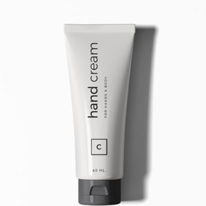 A white tube of hand cream sitting on top of a table.