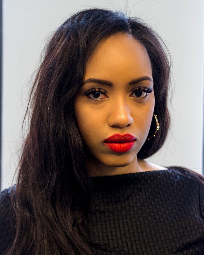 A woman with red lipstick and long hair.