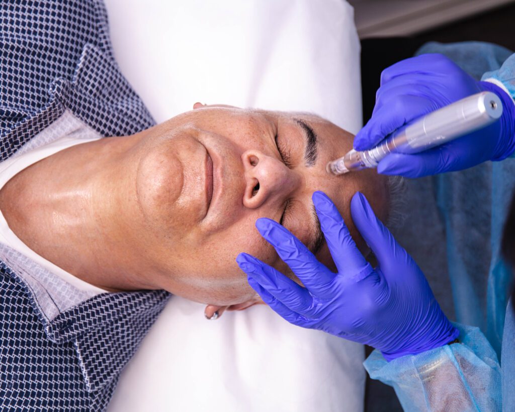 A man getting his face waxed by an esthetician.