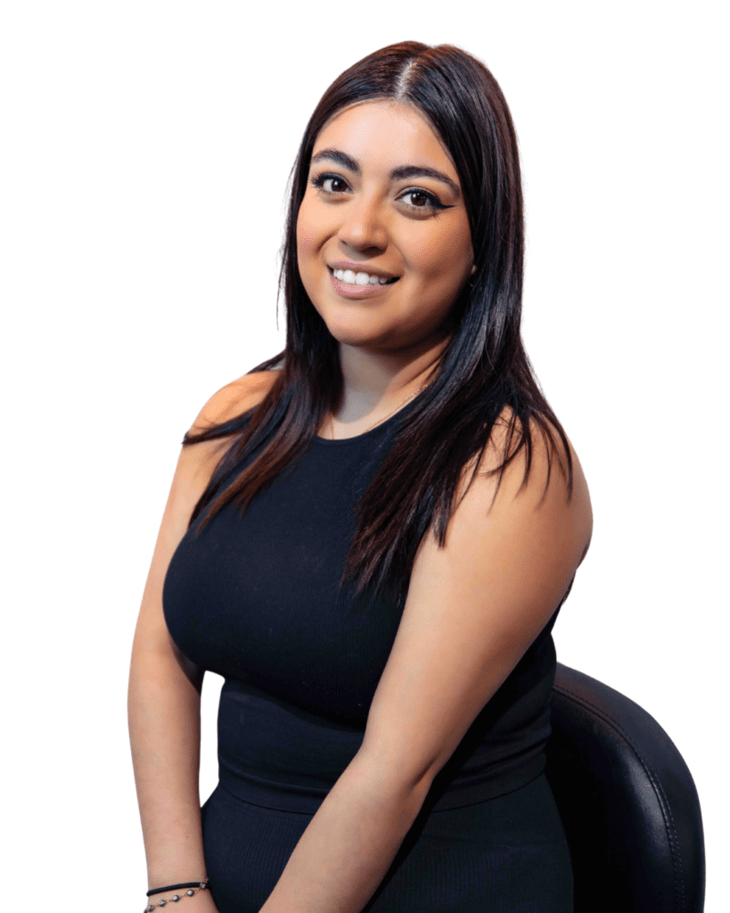 A woman sitting on top of a chair in front of a white wall.